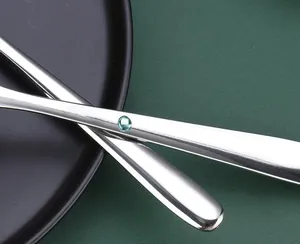 Close-up detail of stainless steel spoon handle with green decorative inset
