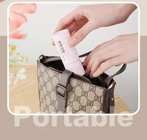 Close-up of portable pink anti-exposure tape being placed inside a stylish handbag