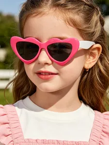 Close-up detail view of a little girl wearing pink candy-colored heart-shaped sunglasses