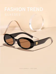 Detail view of stylish retro oval sunglasses featuring a black frame and brown tinted lenses.