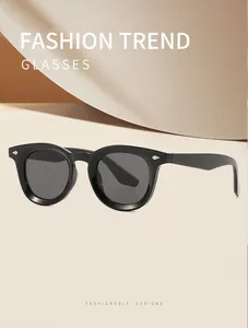Detailed view of retro black oval frame sunglasses with decorative metal studs