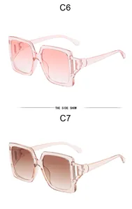 Detalle de gafas de sol cuadradas color gelatina con patillas caladas en rosa