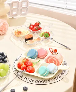 Multi-compartment snack tray with handle holding various desserts and fresh fruits.