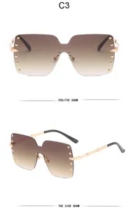Detailed view of oversized rimless sunglasses with gold rivets and gradient brown lenses
