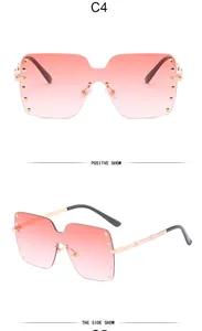 Detailed view of oversized pink gradient rimless sunglasses featuring chic gold rivet accents