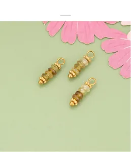 Primer plano de colgantes bohemios de piedras naturales con anillos dorados