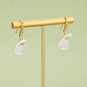 Elegant 18K gold-plated drop earrings with flower charms and pink crystal beads on a stand