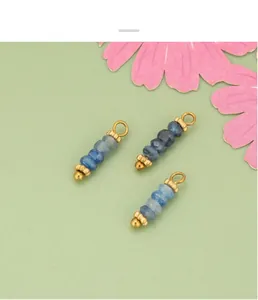 Primer plano de colgantes de cuentas de piedra natural azul con lazos metálicos dorados.
