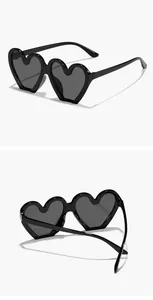 Vista detallada de dos ángulos de lindas gafas de sol negras con forma de corazón para niños