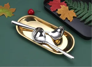 Detailed macro shot of high-quality stainless steel soup ladles on an elegant gold tray