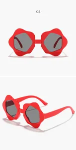 Close-up detail of red flower-shaped children's sunglasses with UV protective grey lenses