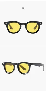 Detailed view of retro oval sunglasses with black frames and yellow lenses