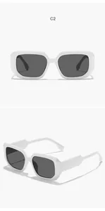 Detail view of white square frame sunglasses with thick edges and dark lenses.