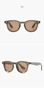 Close-up of retro oval sunglasses with translucent gray frames and amber lenses
