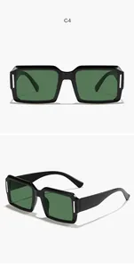 Detailansicht der klobigen schwarzen quadratischen Sonnenbrille mit grünen Gläsern.
