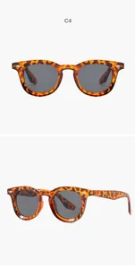 Detailed view of retro tortoiseshell oval sunglasses with silver rivet accents.