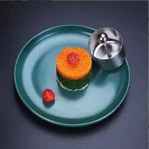 Circular stainless steel food mold for creating layered rice and vegetable towers on a plate
