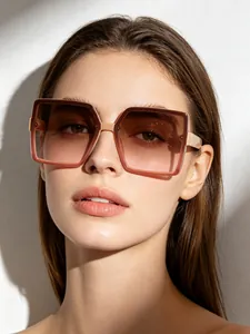 Detail view of a female model wearing oversized square frame brown gradient sunglasses