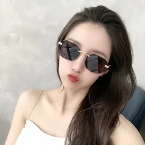 Modische randlose Sonnenbrille mit kleinen Gläsern, Farbverlauf und Goldsteg.