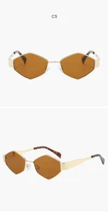 Vue détaillée de lunettes de soleil hexagonales en métal doré avec verres bruns stylés