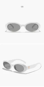 Close-up detail of retro oval sunglasses featuring a white frame and dark grey lenses