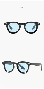 Detail view showing retro oval sunglasses with black frames and stylish light blue lenses.