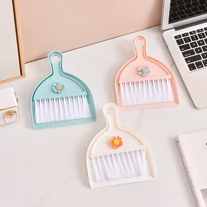 Three pastel colored mini desktop dustpan and broom sets with cute daisy floral accents