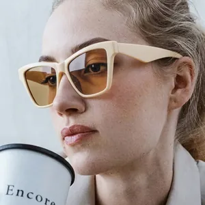 Lunettes de soleil œil de chat élégantes pour femmes avec monture beige et verres teintés.