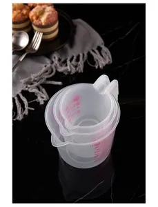 Set of 3 transparent plastic measuring cups with handles and red scale for baking.