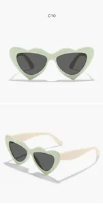 Detailed view of mint green heart-shaped kids sunglasses with stylish cream temples