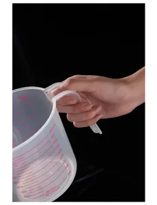 Detail shot of a 1000ml transparent plastic measuring cup with red markings and handle.