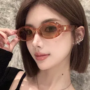 Retro amber oval sunglasses with stylish gold temple detail worn by an Asian model