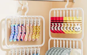 Multi-clip plastic sock drying rack hanging various colorful socks in a laundry scene.