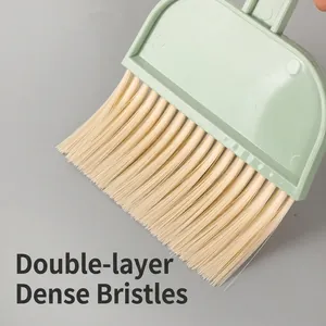 Primo piano di una mini spazzola per pulizia con setole morbide dense e manico verde menta