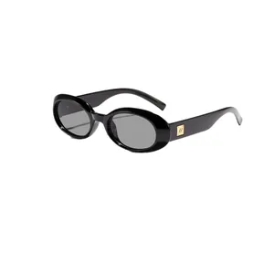Retro oval sunglasses with glossy black frame and metallic gold accent charm