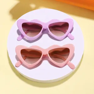 Two pairs of stylish candy-colored heart-shaped sunglasses for kids in pink and purple.