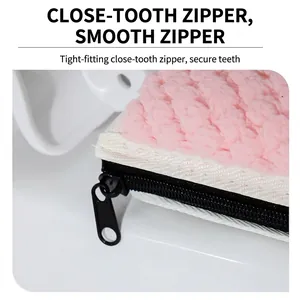 Gros plan sur housse d'abattant WC rose moelleuse avec fermeture éclair noire lisse