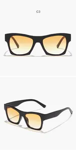 Close-up detail of vintage square black sunglasses with orange gradient lenses.