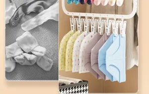 Detail view showing a plastic sock drying rack with multiple clips holding baby clothes