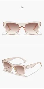 Detail view of retro square sunglasses with transparent pink frames and gradient brown lenses.