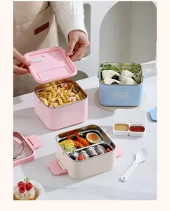 Square stainless steel bento box with pasta and rice balls in a clean kitchen setting