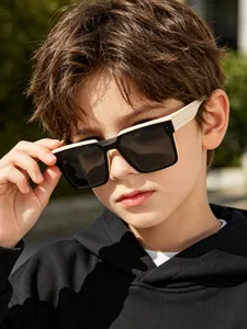 Close-up of a boy wearing stylish square-frame sunglasses in black and cream finish.