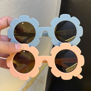 Süße Kinder-Sonnenbrille in Blumenform in Hellblau und Pfirsichfarben