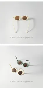 Detailed close-up of stylish round frame sunglasses for kids in cream and sage green