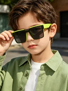 Young boy wearing neon green square frame fashion sunglasses in stylish outdoor street setting