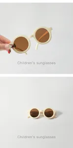 Detailed macro view of beige round-framed sunglasses for kids with dark brown lenses.