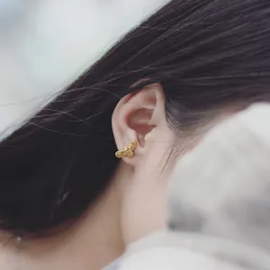 Elegante retro gouden vliegende arend oorsteker van titaniumstaal op een Aziatisch model.