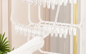 Detail view showing the multiple clips on a white plastic drying rack for socks