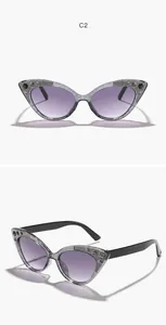 Macro detail of glittery cat-eye sunglasses with rhinestone embellishments for kids.