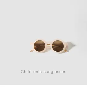 Detail view of round cream children's sunglasses featuring stylish brown lenses